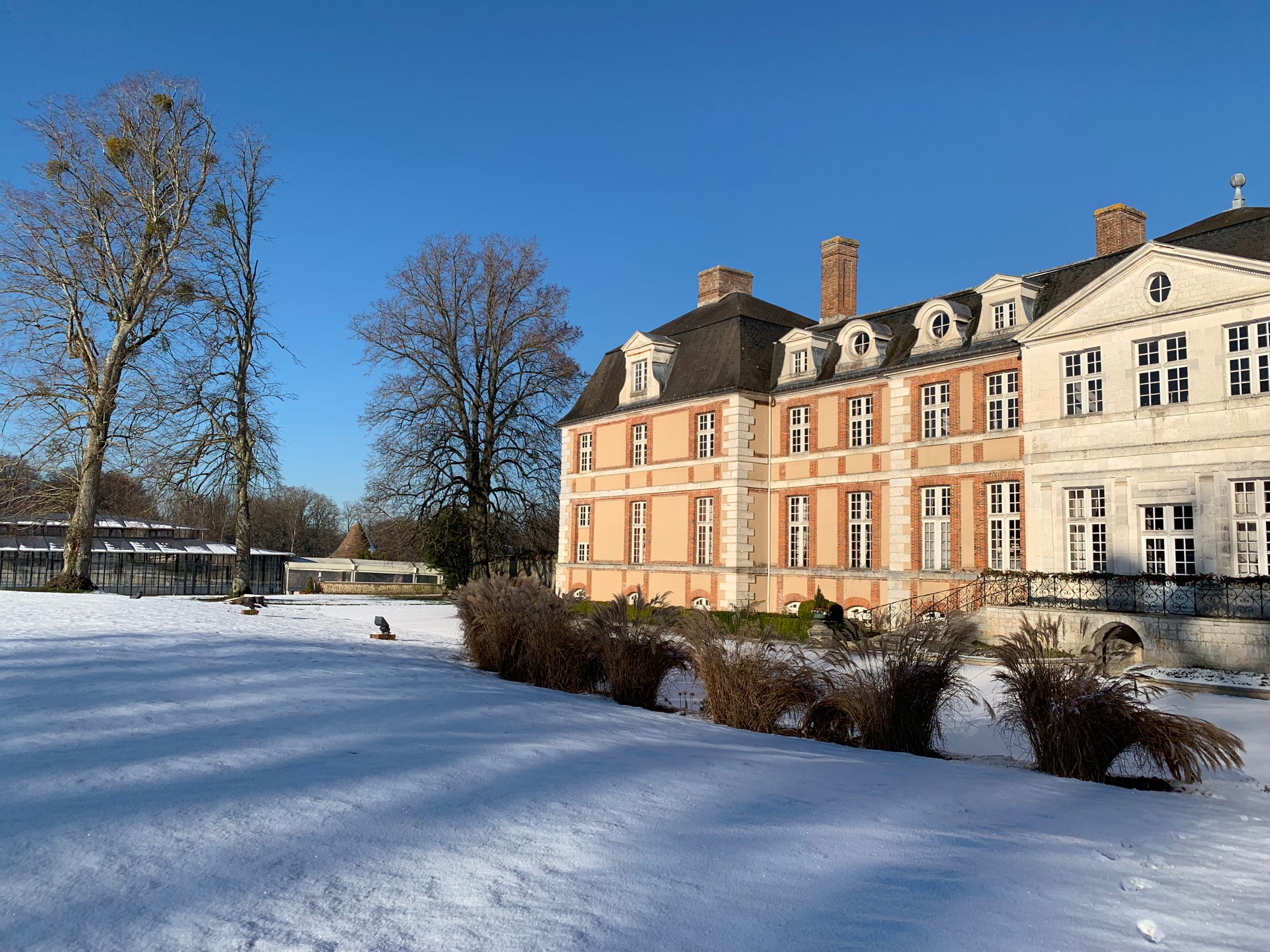 Par une belle journée ensoleillée, le Château d'Argeronne et son Orangerie sous la neige de l'hiver 2023-2024